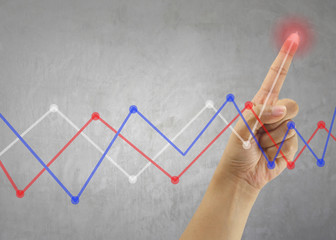 Finger of Businessman touch line graph business in peak point.