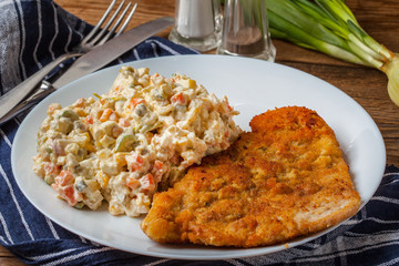 Fried pork chop in breadcrumbs, served with vegetable salad.