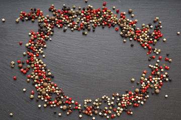 pepper scattered on slate, top view, a place for an inscription