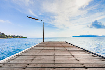Fototapeta na wymiar Wooden plank pier with seascape and bright blue sky