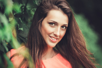 Naklejka premium Happy beautiful young woman in spring blossom park. Pretty Girl with Spring Flowers. Fashion Model Outdoors