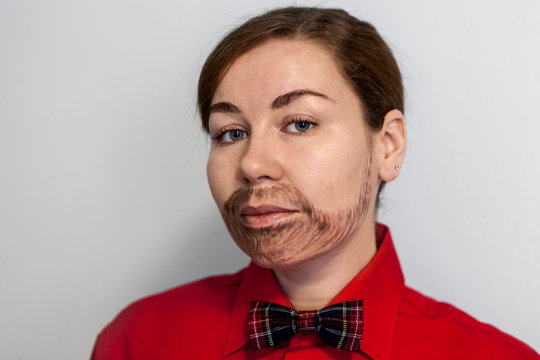 Caucasian young woman with painted beard. Wearing lake a man in red shirt and a bow tie. Male hairstyle