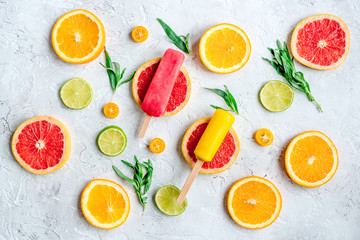 citrus popsicles with fruit slices on stone background top view pattern
