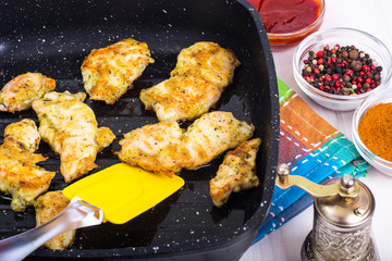 Chicken fillet slices on grill pan