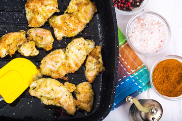 Chicken fillet slices on grill pan