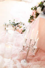 Candles near the wedding table in ivory colors