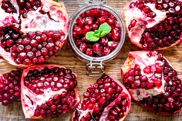 sliced pomegranate on wooden background top view