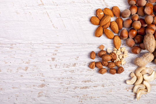 Different Nuts On Wooden Background