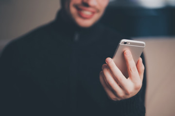 Man is smiling while searching on smart phone