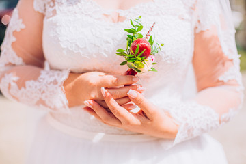 Bride holding a buttonhole. Gentle hand of the woman for the groom.