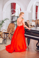 beautiful young woman in a red dress near a mirror