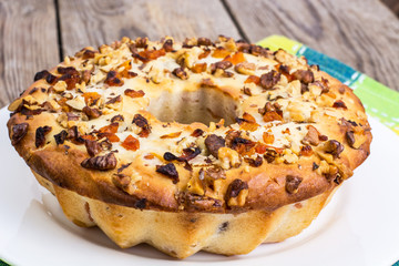 Cake with nuts and dried apricots on wooden background