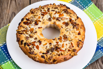 Cake with nuts and dried apricots on wooden background