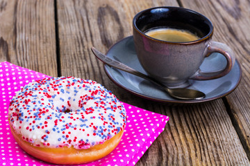One donut with white frosting and colored sprinkles candy