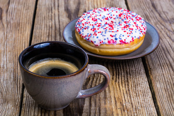 One donut with white frosting and colored sprinkles candy