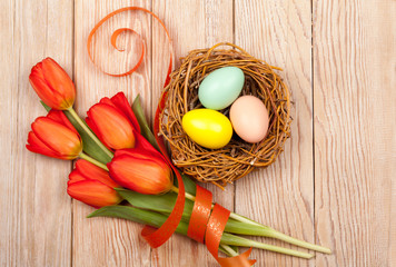 Easter Eggs in a birds nest with colorful tulips