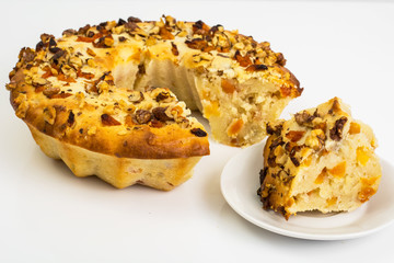 Curd cake with nuts and dried apricots on white background
