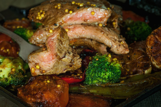 Beef steak on a grill with vegetables