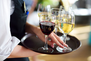 Waitress holding a dish of champagne and wine glasses at festive event