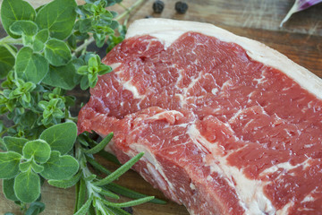 Raw Beef Steak with Fresh Herbs on Board