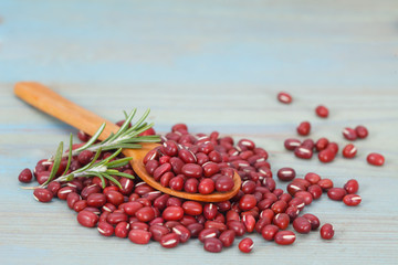 Pile of red azuki beans with rosemary on blue background. Vegan vegetarian healthy food.
