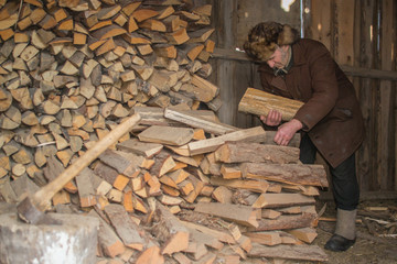 an elderly man in a cap with earflaps firewoods holding hands