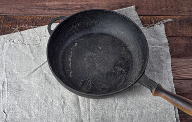 empty black cast iron pan on textile napkin