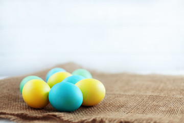 Colored eggs lying on the sacking. The concept of a happy Easter.