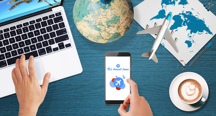 Top view of hands searching trip destination online on phone and using laptop