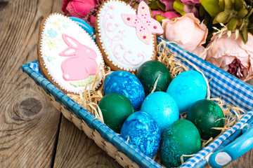 Easter colored eggs, straw, flowers