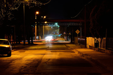 Nocna ulica oświetlona lampami i samochody w ruchu. - obrazy, fototapety, plakaty