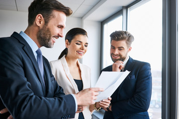 Fototapeta na wymiar Business people standing together in office discussing documents