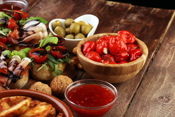 Italian antipasti wine snacks set. Cheese variety, Mediterranean olives, pickles, Prosciutto di Parma, tomatoes, artichokes and wine in glasses