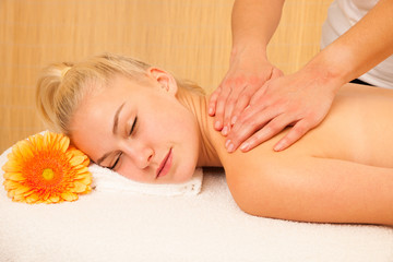 Fototapeta na wymiar Beautiful blonde woman enyoing massage treatment in sap salon