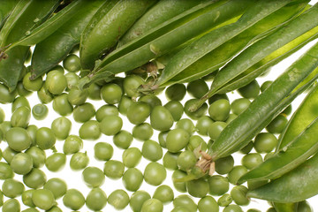 Fresh raw green peas and empty pods on white background