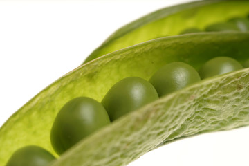 Fresh raw green peas within a pods on white background