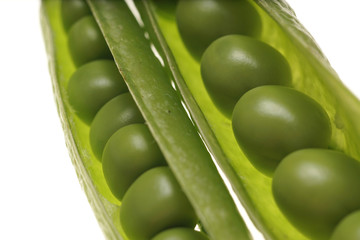 Fresh raw green peas within a pods on white background