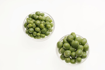 Fresh raw green peas on white background