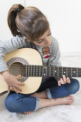 9 year old girl learning to play the guitar.