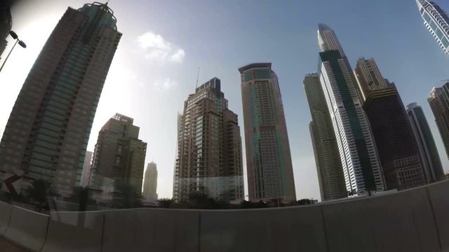 the view from the car window at skyscrapers standing along the road. Dubai, United Arab Emirates