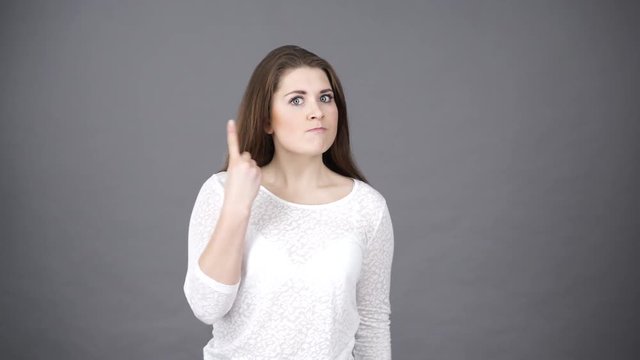 Woman furiously and frustrated screaming, feel anger and irritation. Hands in air open mouth, shaking finger. Negative emotions, emotional tension
concept. Studio shot on grey 4K ProRes HQ code