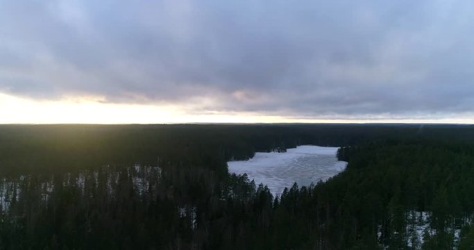 Nuuksio winter, Cinema 4k aerial above the forrest of Nuuksio, with a sun glimps on a cloudy winter day, in Nuuksio national park, Finland