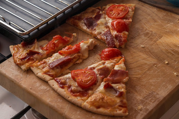 Hot pieces of pizza on a wooden board