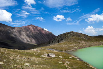 Fototapeta premium Amazing picture of green mountain landscape with blue sky and white clouds. Great nature,sunlight at the middle of summer day. Lake and color hill.
