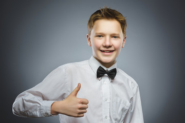 Closeup portrait successful happy boy show thumb up isolated grey background.