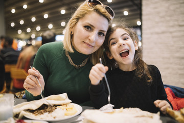 Mother And Daughter Eating In Restaurant