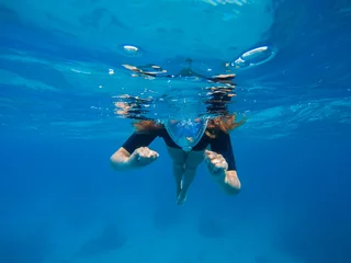 Photo sur Plexiglas Plonger Woman swimming in blue water. Beautiful woman under water before dive to coral reef.
