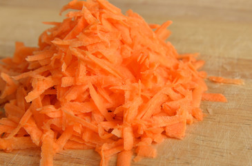 Drated carrots on wooden.