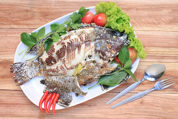 Tilapia fish grilled with Salt in white dish.