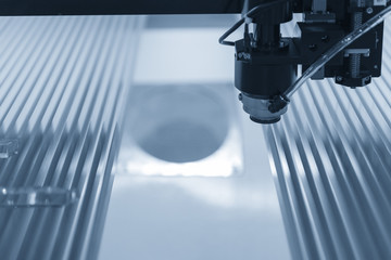 The laser cutter machine while cutting the sheet metal in light blue scene
